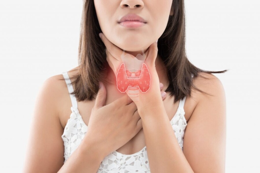 woman holding her neck with an image of the thyroid gland. Hypothyroidism affects the thyroid gland