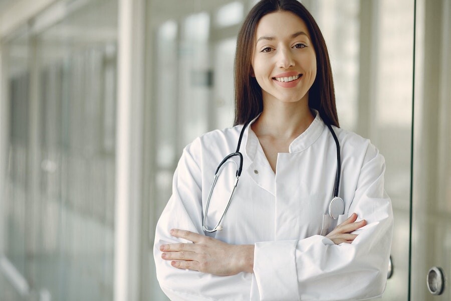 doctor standing in hospital setting smiling at patient