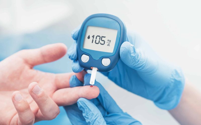 Doctor checking blood sugar level with glucometer. Treatment of diabetes concept.