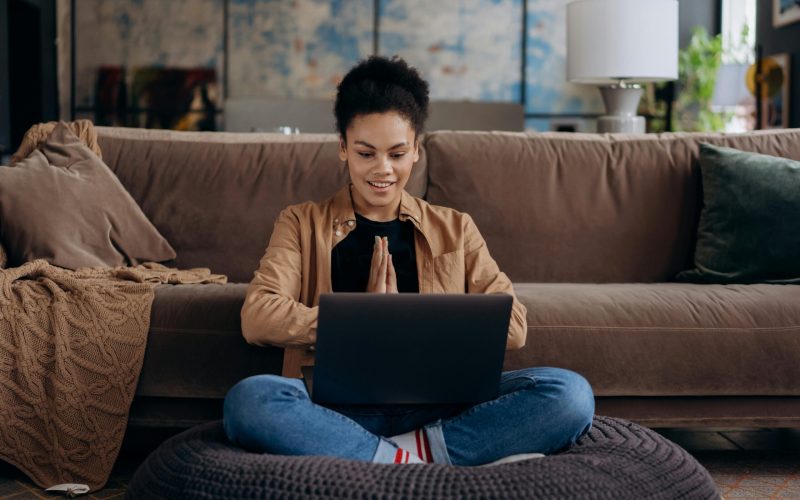 woman on couch typing on computer